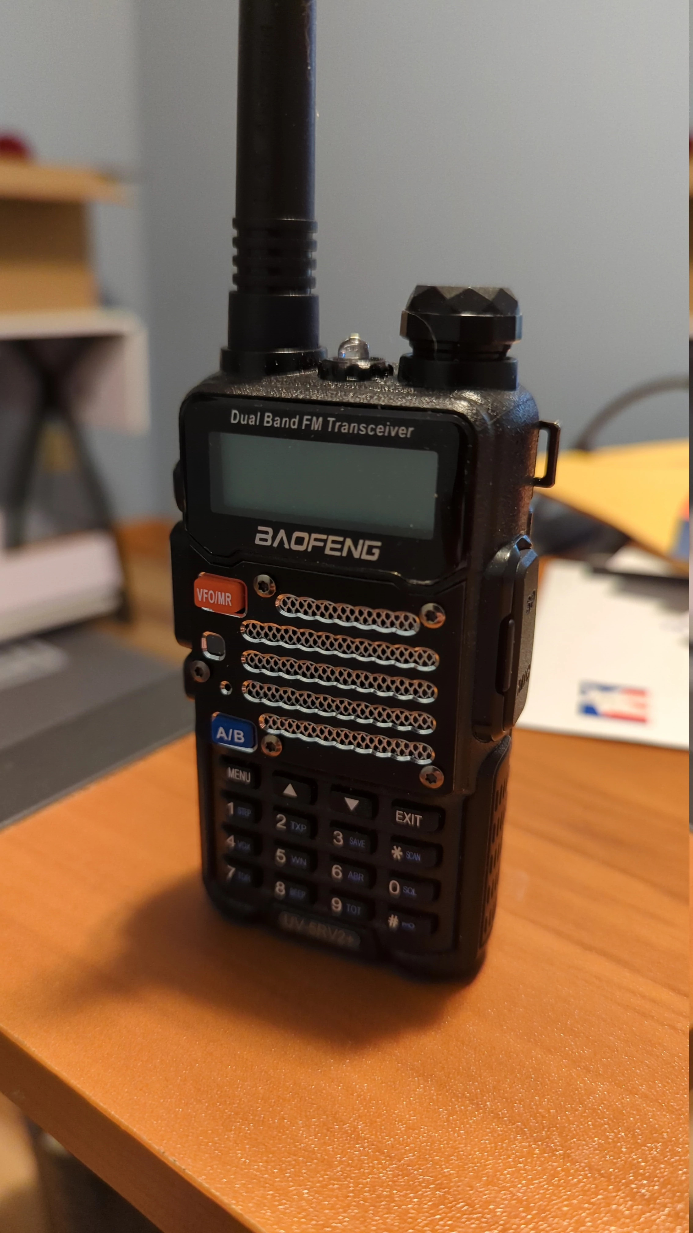 Baofeng UV-5RV2+ handheld radio with rubber duck antenna on a table