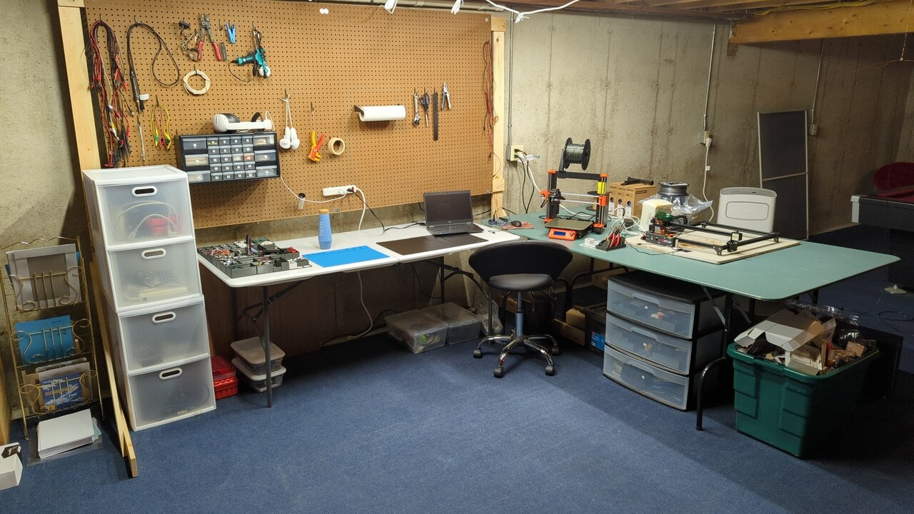 My lab at the end of this project. The tables are rearranged and have lots of working space on them. A large pegboard and some plastic drawers surround the tables. The lights are much brighter.