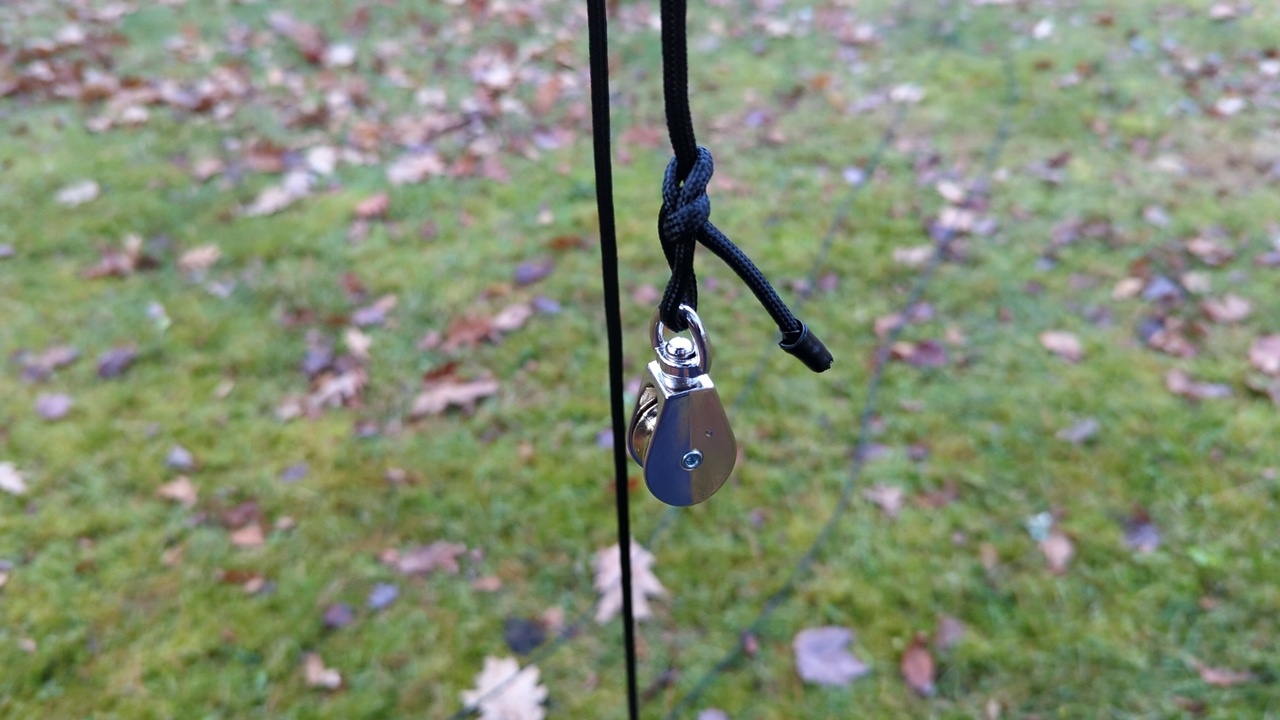 Pulley hanging from a rope, ready to be threaded with a second rope and hoisted up