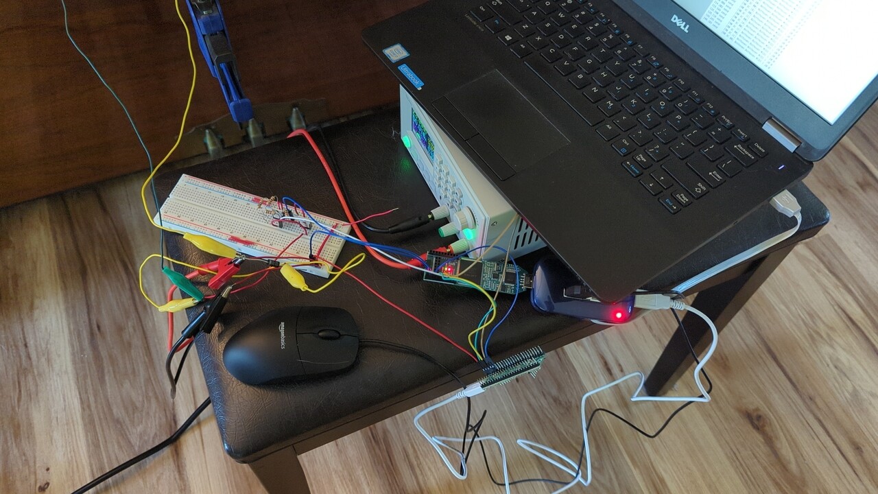 Laptop, power supply, breadboard, FPGA dev board, and a mess of wires all on top of a piano bench