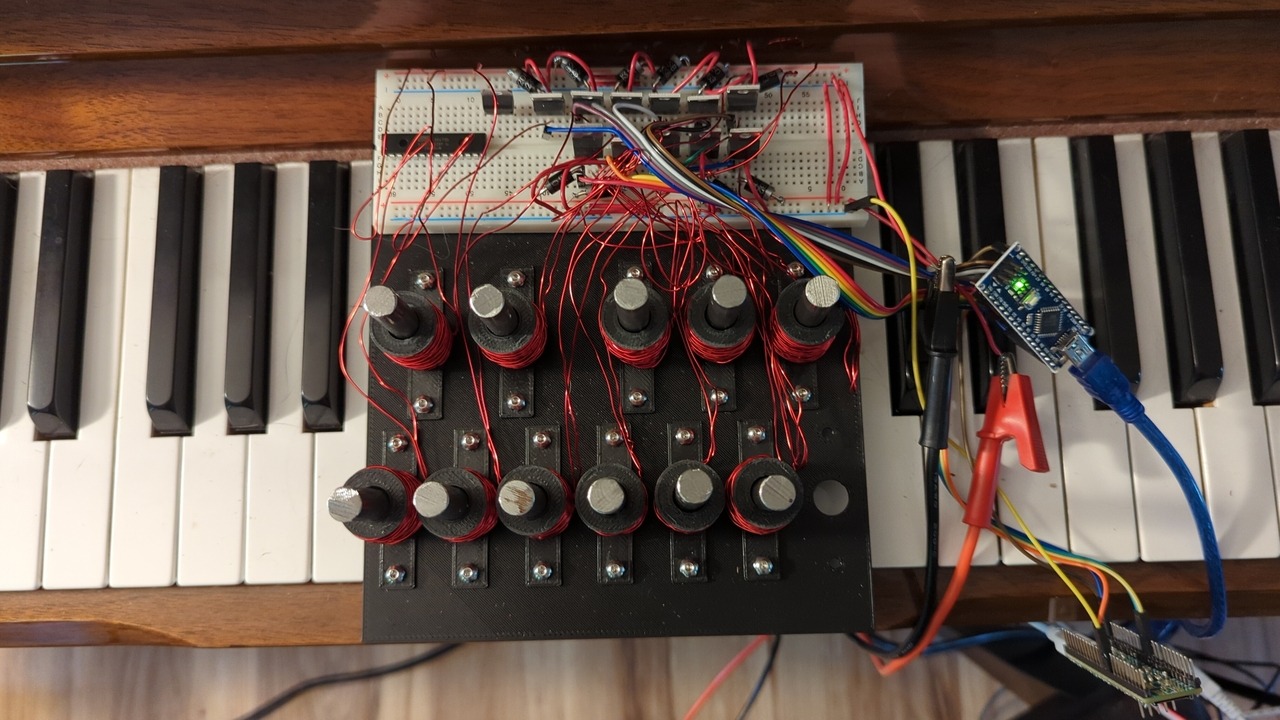 Top view of the key platform, solenoids, plungers, and breadboarded driver circuit all installed on the piano