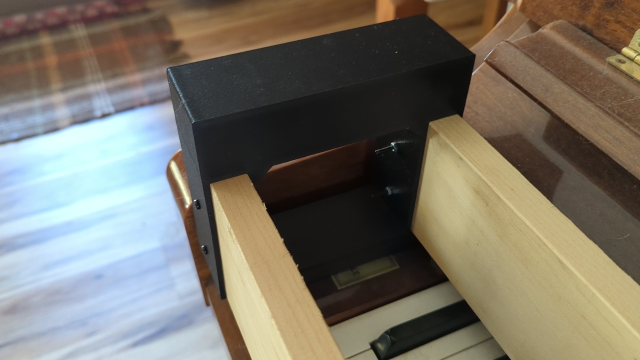 Close view of the end support on the far left side of the keyboard. Four M3 screws secure the plastic to the wood.