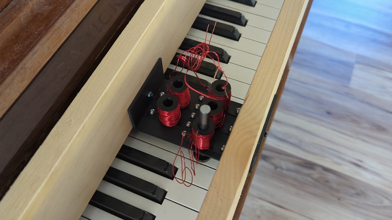 View from above of a small key platform bolted to the wooden boards so it hangs underneath them. A group of five keys starting on C4 has been populated with solenoids, but they aren’t connected to anything.