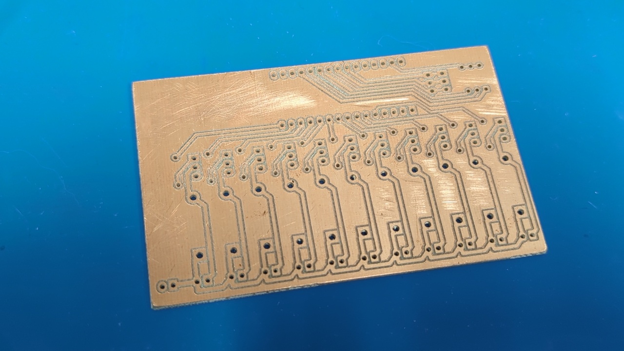 A freshly-cut printed circuit board laying on a blue silicone mat