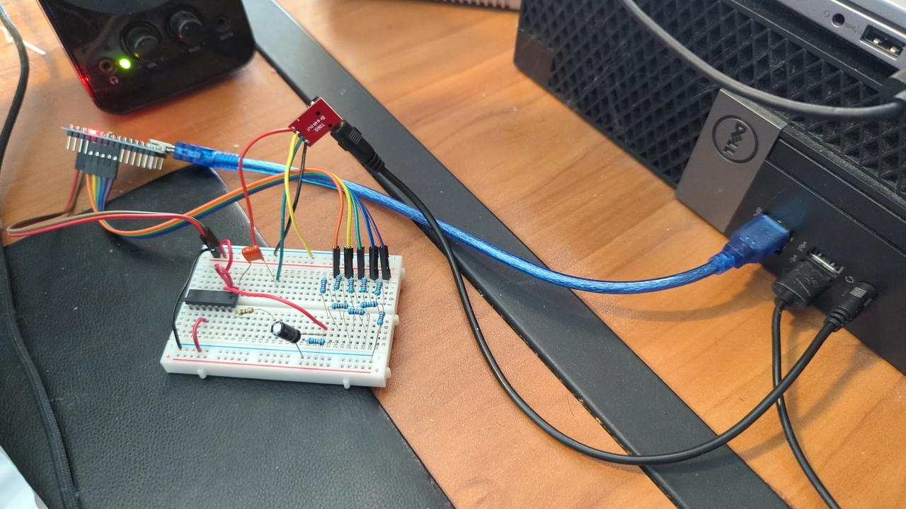An Arduino Nano connected to a breadboard with various components, all of which is connected to a desktop machine