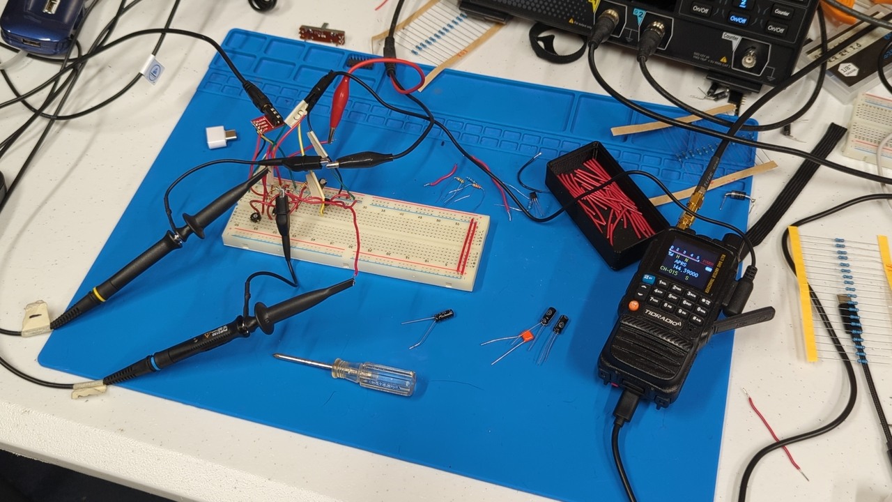 Breadboard with various components, wires, and scope probes on a blue silicone mat. One of the cables is connected to the audio connector of my handheld transceiver.
