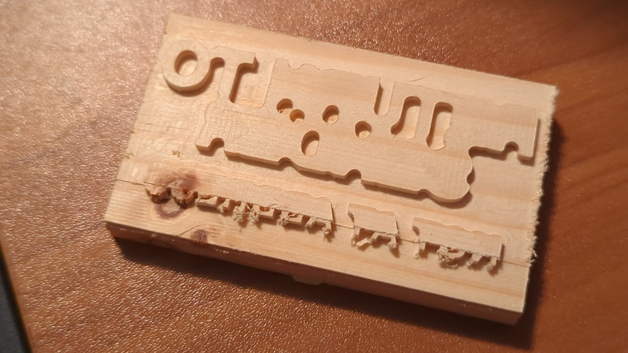 Wooden stamp with unfinished letters. The very bottom of the last row of text has more detail.