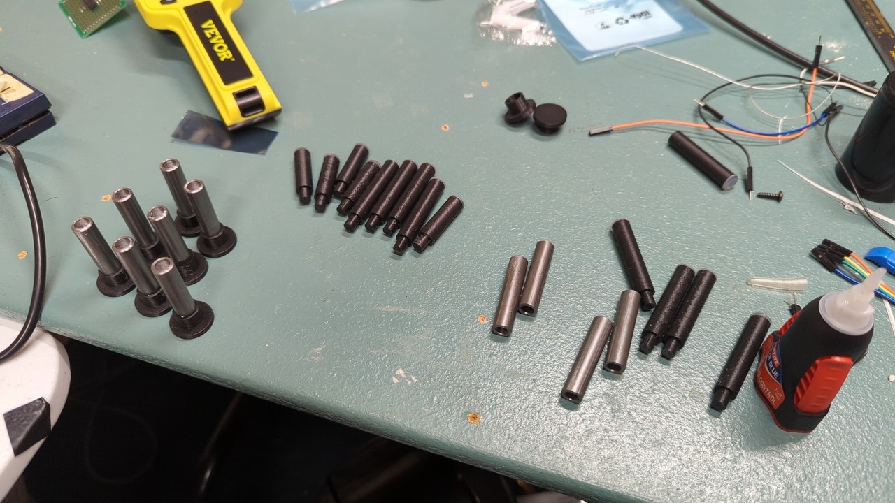 Plungers in the process of being assembled. Drilled steel rods next to plastic extensions.