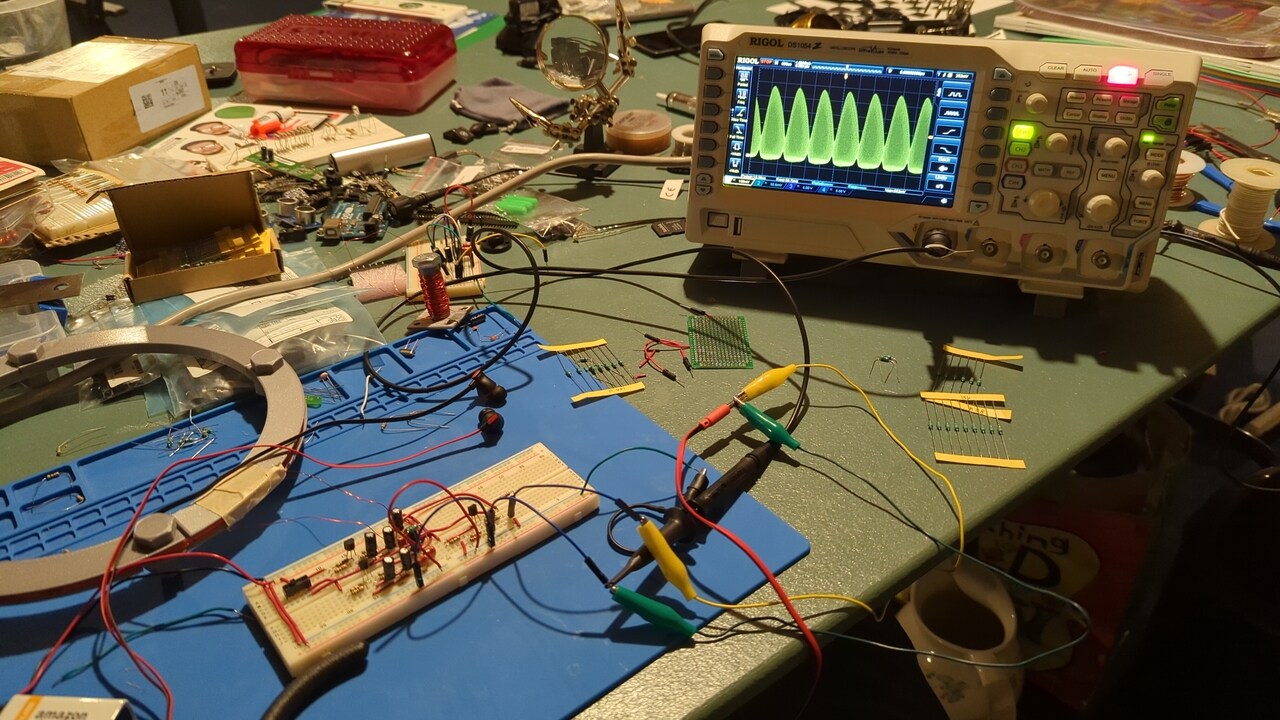 Lab bench with the breadboard iteration of the circuit and my oscilloscope showing its output