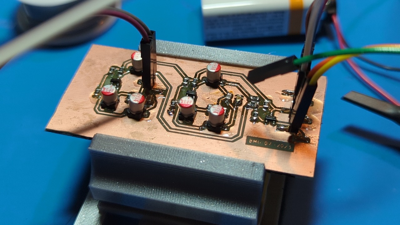 Fully-assembled metal detector circuit on a homemade PCB. The board is currently under test and is being held by a 3D-printed vise