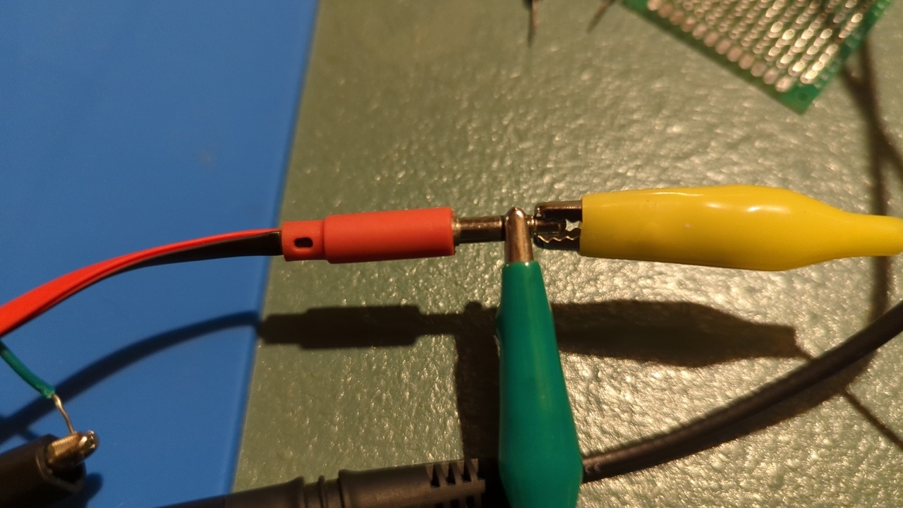 The TRS connector for my earbuds with two alligator clips connected, one to the ring and the other to the tip